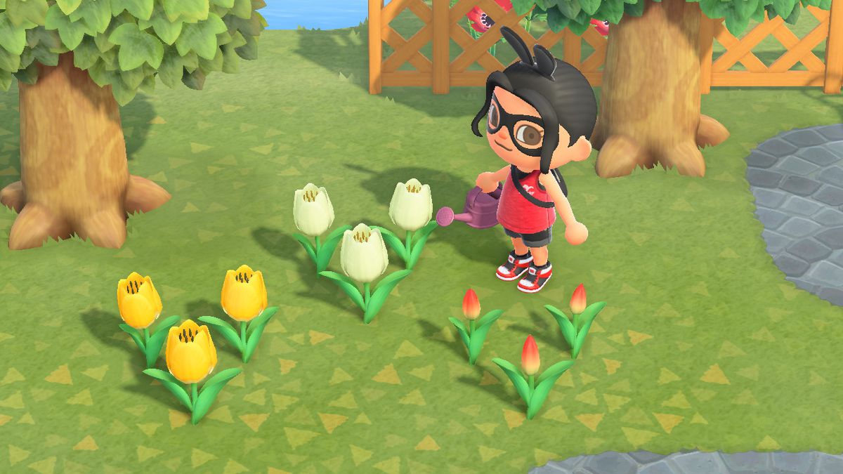 An Animal Crossing character stands near an array of tulips